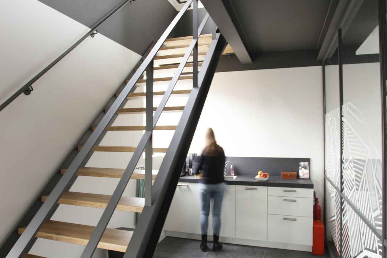 Stalen trap met houten treden op een accountantskantoor in Koewacht
